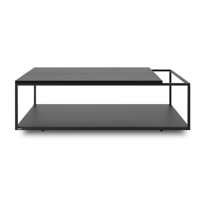 Mesa de centro Salto con cubierta de madera teñida negra, estructura de acero negro y repisa inferior, sobre fondo blanco