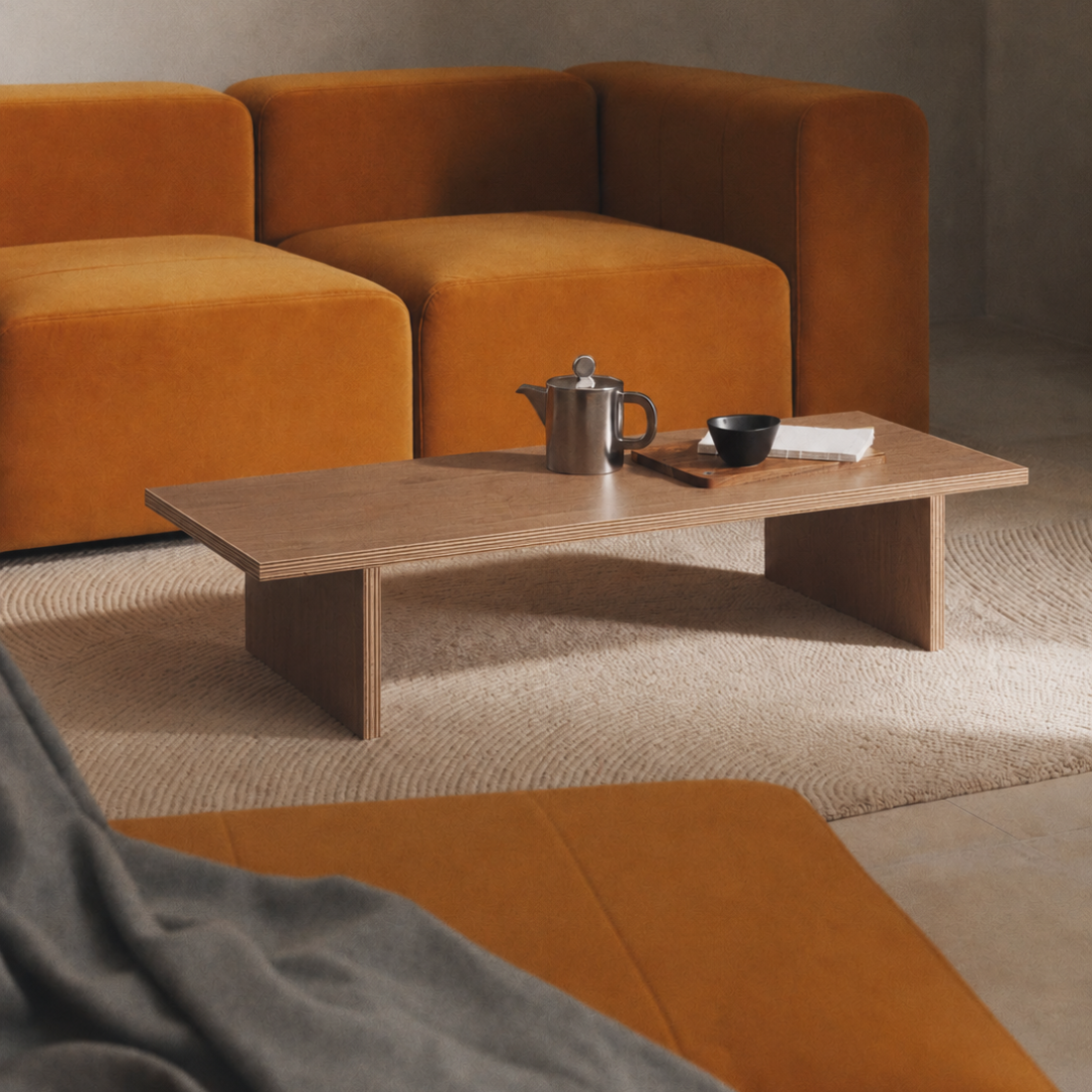 Mesa de centro de madera en tono nogal, frente a un sofá modular naranjo