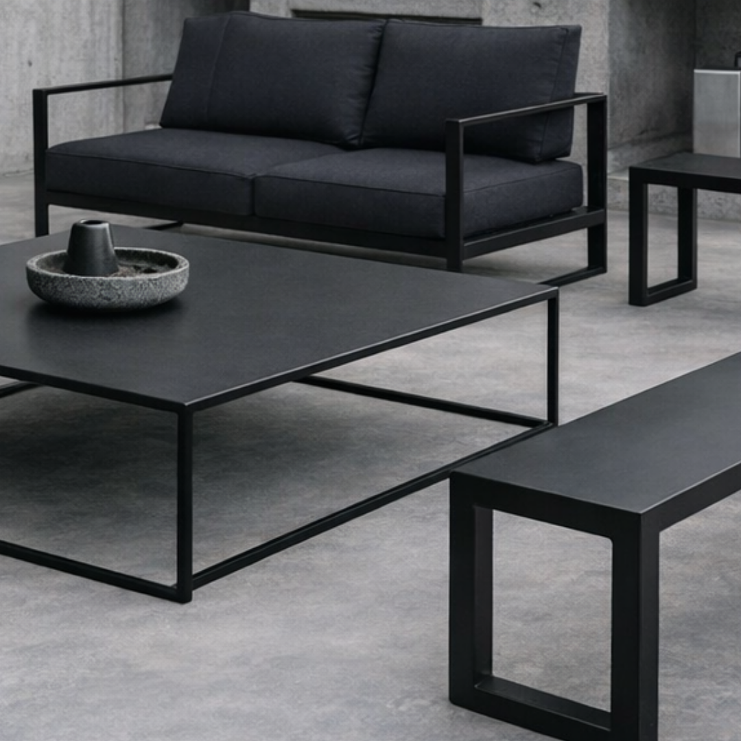 Mesa de centro de metal en un living con piso de hormigón