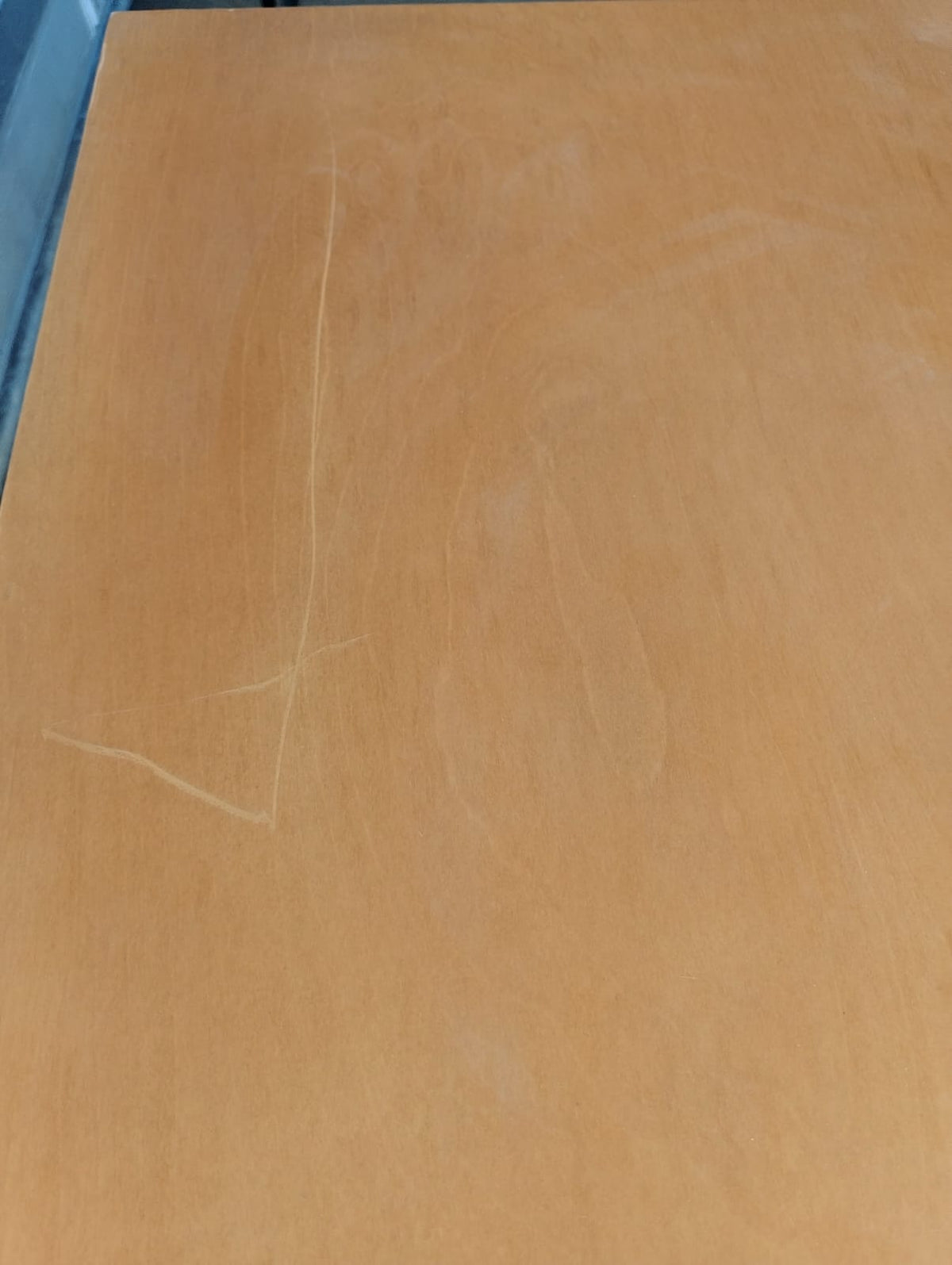 Detalle de la cubierta del velador a contraluz, con marcas finas sobre la veta