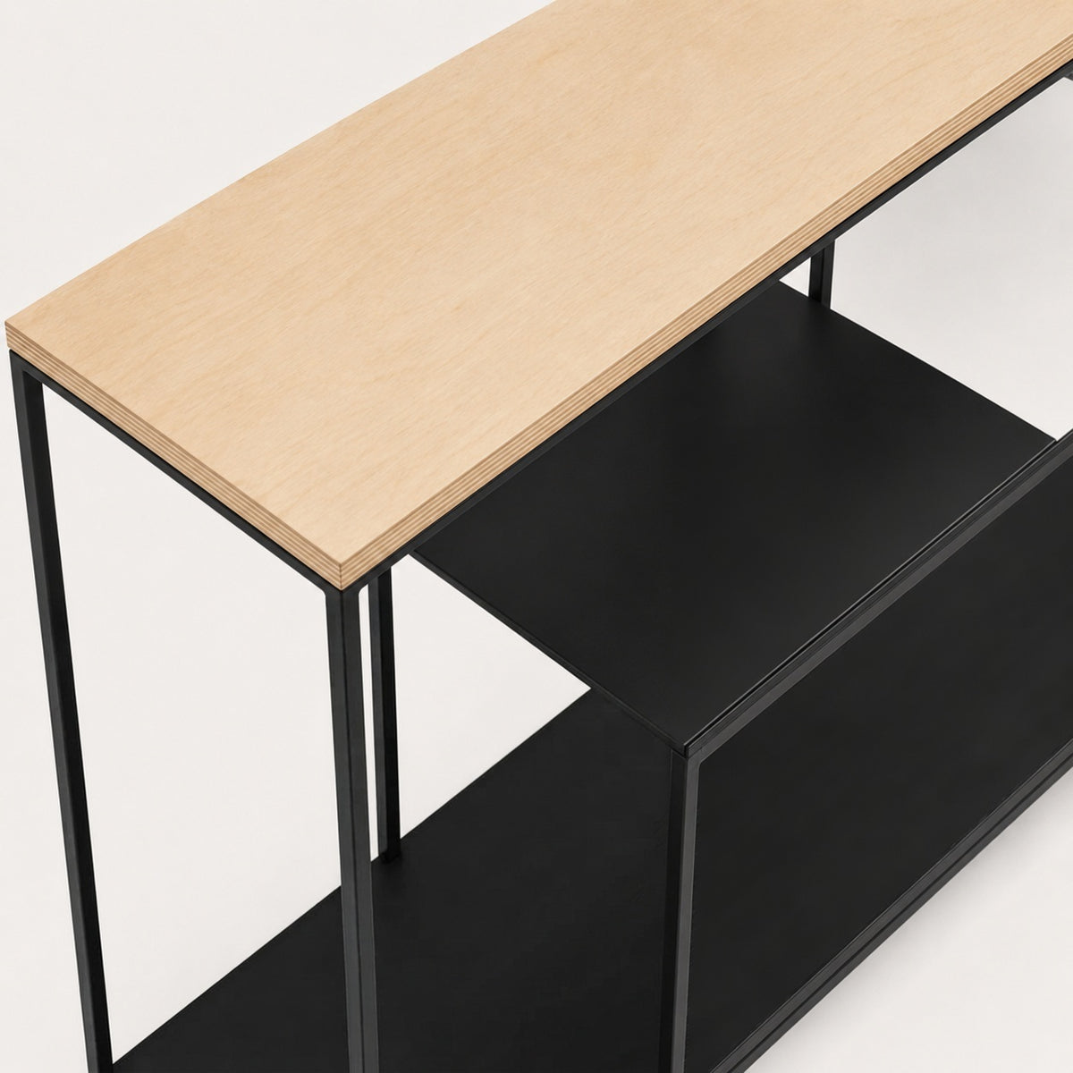 Detalle del canto de la cubierta de plywood de abedul y su encuentro con la repisa negra y el perfil de acero
