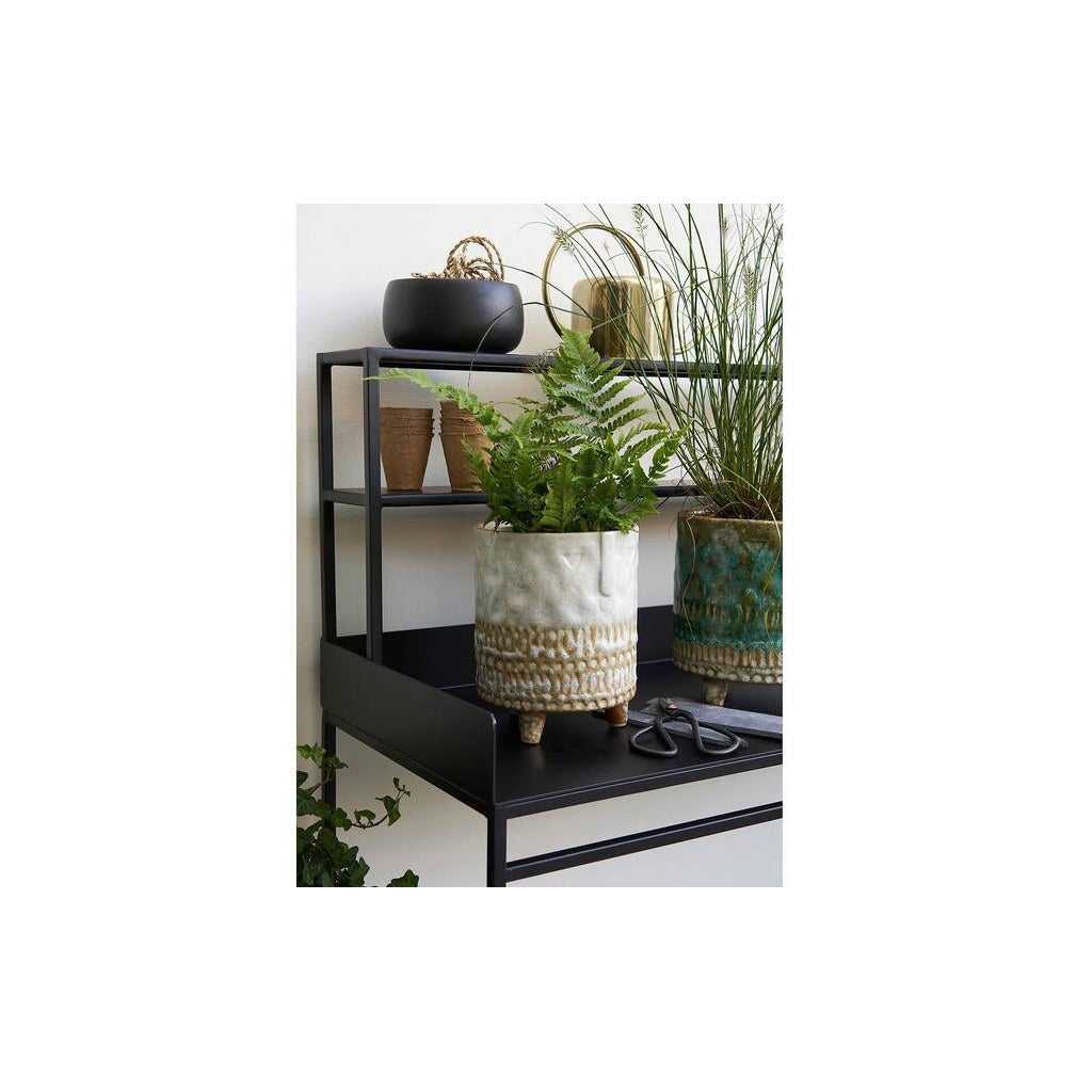 Estantería Consuela Kallfü metal negro decorada con plantas — ambiente interior