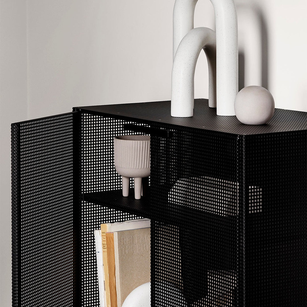 Detalle de la plancha de metal perforado negro del Gabinete 76 Gridline Kallfü y su repisa interior