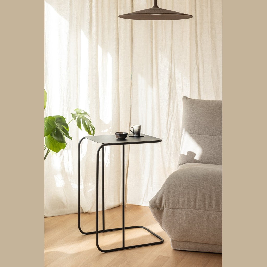 Mesa lateral Denya Kallfü metal negro en living junto al sofá con planta — ambiente
