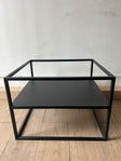 Mesa Melín de metal negro de 55 × 50 cm, sin vidrio, vista de frente con su repisa inferior de metal