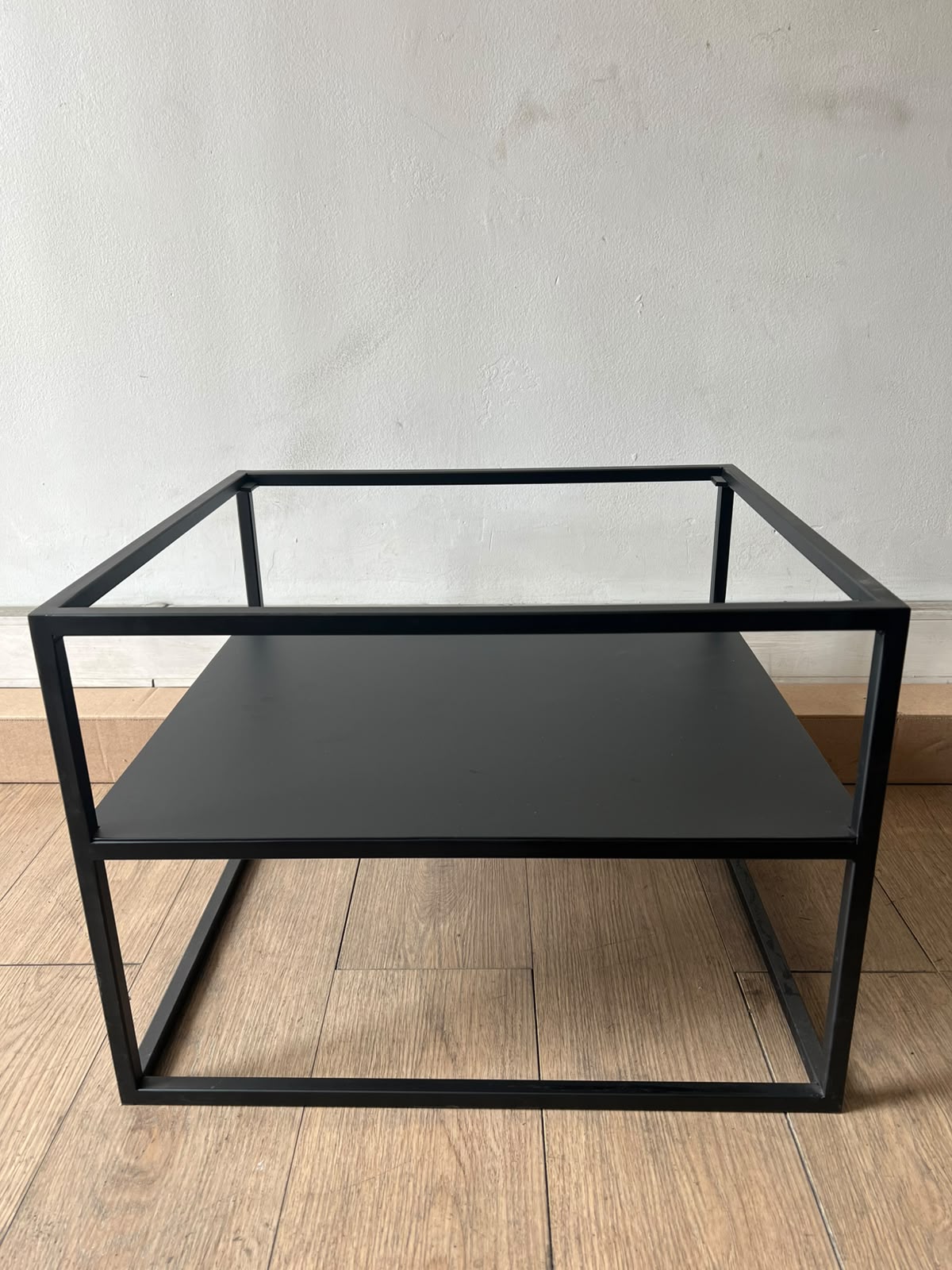Mesa Melín de metal negro de 55 × 50 cm, sin vidrio, vista de frente con su repisa inferior de metal